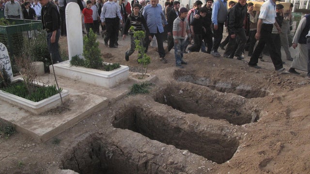 Graves for four people killed in a raid by Syrian government forces in Damascus 