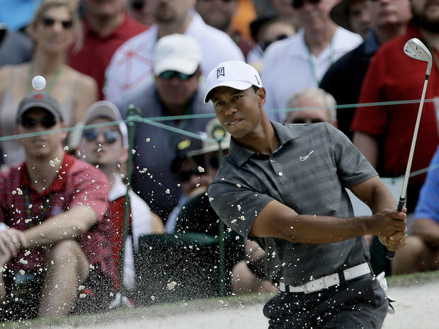 Tiger Woods chips out of a bunker on the seventh hole  