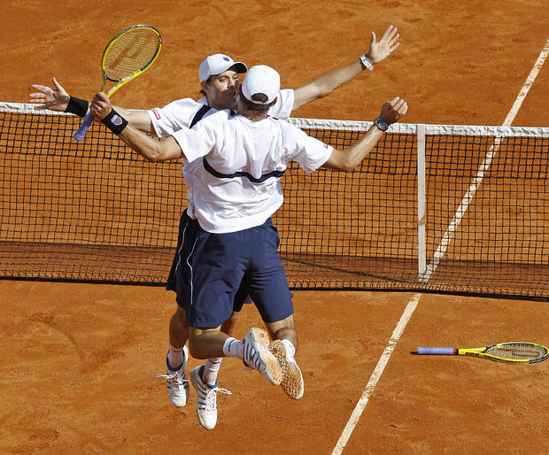 U.S. players Mike Bryan, facing, and Bob Bryan react after winning their men's doubles match 