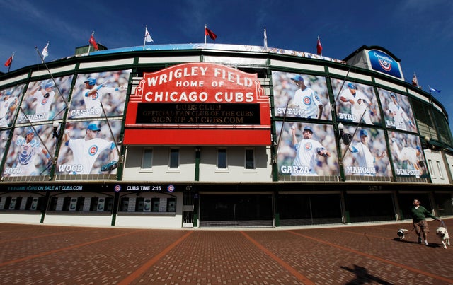 A man walks his dogs by Wrigley Field 
