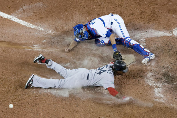 Darnell McDonald slides into home plate to score against Toronto Blue Jays catcher J.P Arencibia  