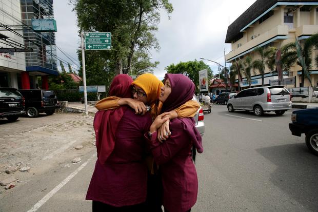 Acehnese women hug each other and pray shortly after a powerful earthquake 