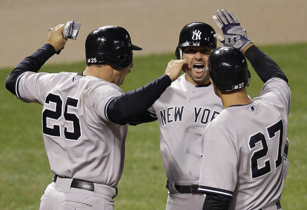 Nick Swisher meets Mark Teixeira and Raul Ibanez at home plate after a home run 