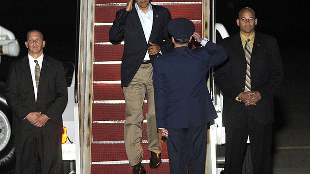 President Barack Obama salutes an Air Force officer as he walks down the stairs of Air Force One at Andrews Air Force Base, Md., April 15, 2012.  