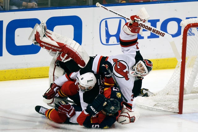 Marcel Goc and Andy Greene collide with Devils goalie Martin Brodeur 