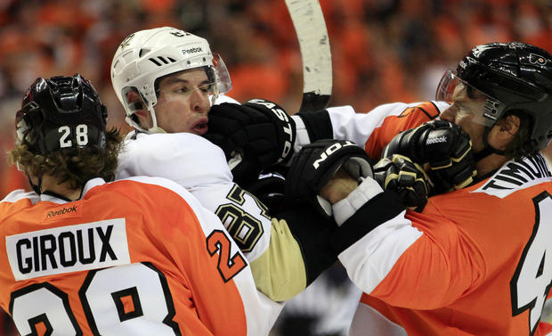Claude Giroux holds on to Sidney Crosby as Kimmo Timonen lands a punch  