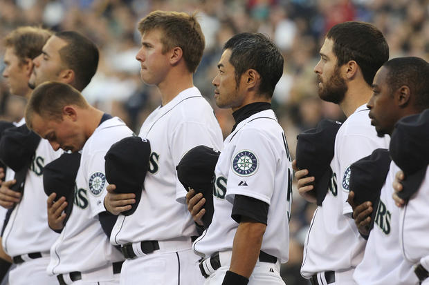 Ichiro Suzuki and other members of the Seattle Mariners stand at attention 