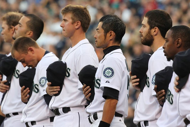 Ichiro Suzuki and other members of the Seattle Mariners stand at attention 