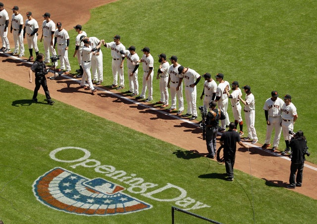 Buster Posey is greeted by teammates during introductions 