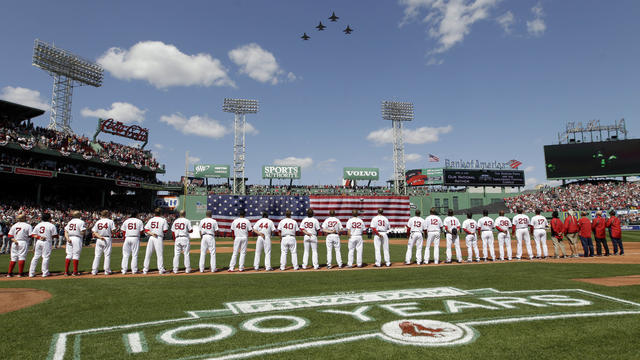 Boston Red Sox players line up for the national anthem as fighter jets from the Vermont National Guard fly over Fenway Park 