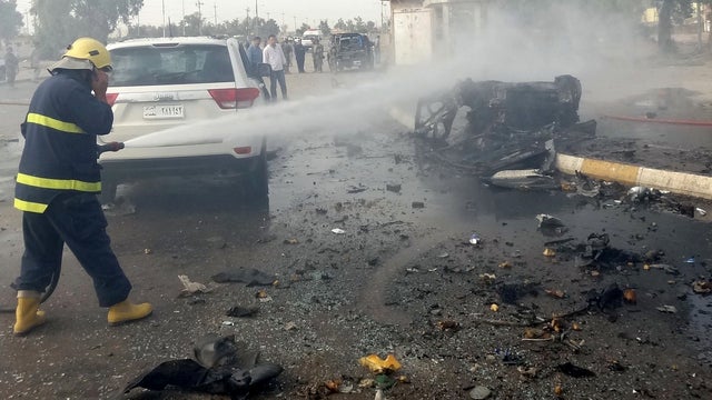 Iraqi firefighters douse the scene of two car bombs close to the governate in the northern oil-rich city of Kirkuk, Iraq, April 19, 2012, which left several people dead. 