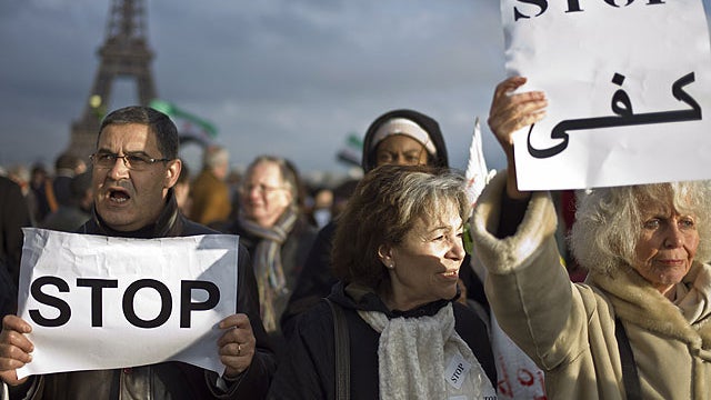 Activists hold placards reading 'stop' during the 'White Wave' campaign to protest against the violence in Syria, in Paris, April 17, 2012. 