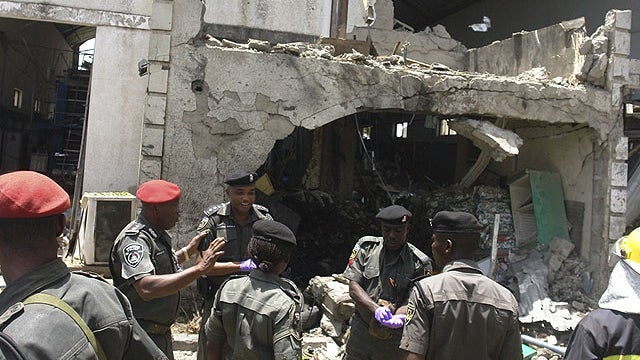 Police and rescuers stand in front of the bombed office of ThisDay, an influential daily newspaper in Abuja, Nigeria, April 26, 2012. 