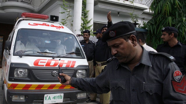 An ambulance removes dead bodies of shooting victims from a house in Lahore, Pakistan, April 30, 2012. 