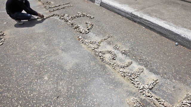 Egyptian protester arranges rocks to read in Arabic: "down with military rule" 