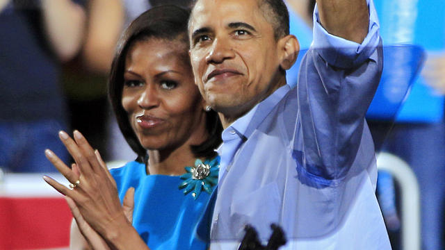 President Barack Obama waves with first lady Michelle Obama after a campaign rally 