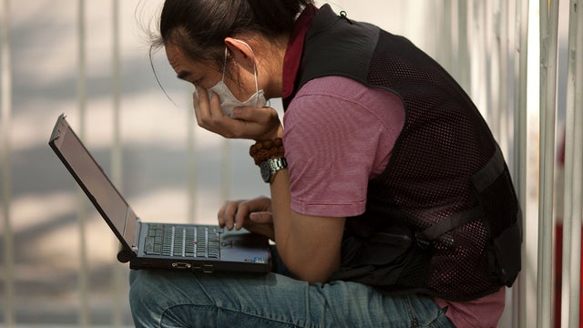 A foreign journalist works on a laptop computer in a police cordon outside Chaoyang hospital, where blind Chinese activist Chen Guangcheng is receiving treatment, in Beijing May 8, 2012. 