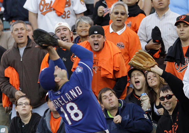 Fans watch as Texas Rangers first baseman Mitch Moreland catches a pop fly 