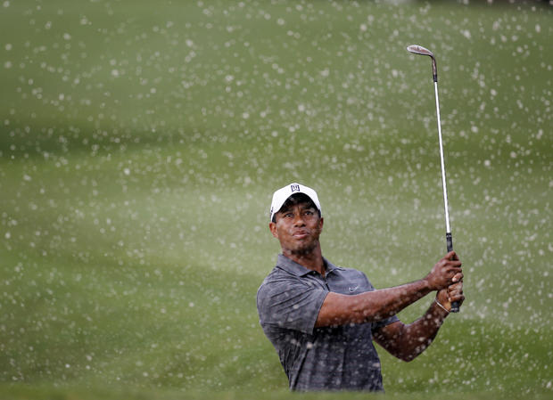 Tiger Woods watches his shot from a 10th hole bunker 