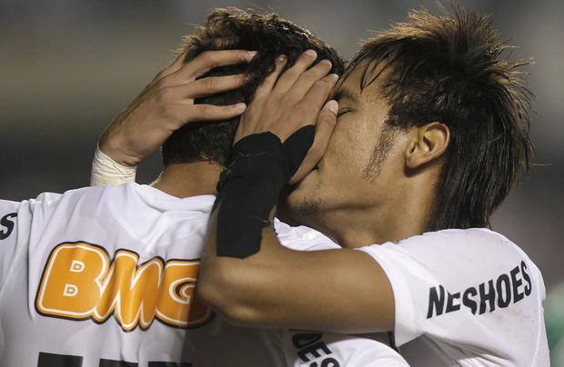 Santos' Neymar, right, embraces teammate Paulo Henrique Ganso 