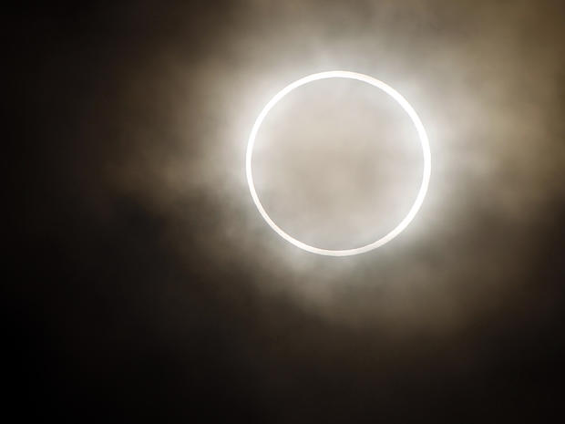The moon slides across the sun, showing a blazing halo of light, during an annular eclipse at a waterfront park in Yokohama, Japan, May 21, 2012. 