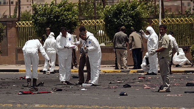 A policeman collects evidence at the site of a suicide bomb attack at a parade square in Sanaa, Yemen, May 21, 2012.  