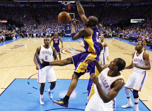 Kobe Bryant dunks in front of Kendrick Perkins 