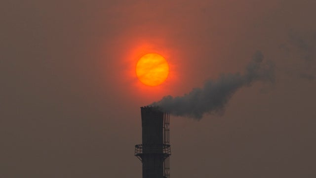 Smoke billows from a chimney of a heating plant as the sun sets in Beijing in this file photo dated Monday, Feb. 13, 2012. U.N. climate talks being held in Bonn, Germany, are in gridlock May 24, 2012. 