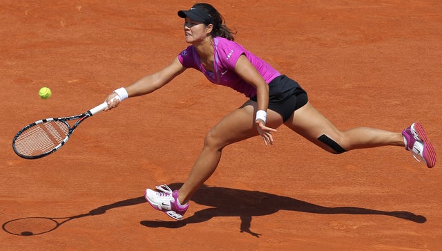 Li Na of China returns in her first round match against Sorana Cirste 