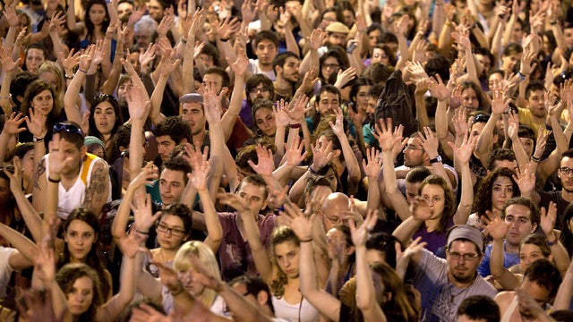 Protesters with Spain's Indignant movement raise their hands in the air during a rally at Puerta del Sol May 15, 2012, in Madrid. 
