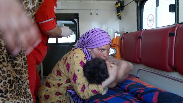 	A woman embraces an injured Syrian boy in a Lebanese Red Cross ambulance after he was smuggled into the northern Lebanese town of Wadi Khaled, bordering with Syria for treatment on May 30, 2012. 