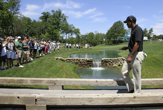 Tiger Woods walks on a bridge to the 15th tee  