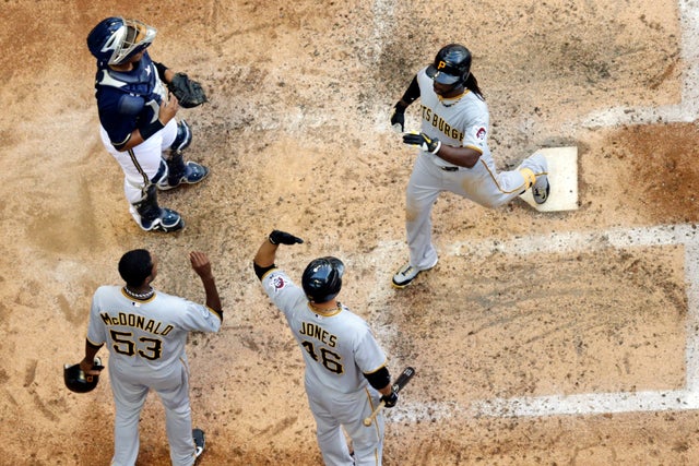Martin Maldonado watches as Andrew McCutchen is congratulated at home by Garrett Jones  