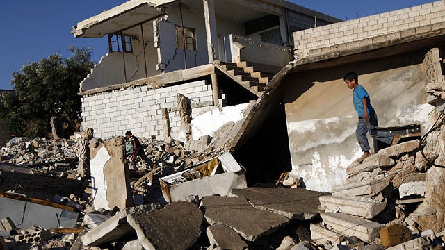 Syrian boys play in the rubble of house which was destroyed during a military operation by the Syrian pro-Assad army in April 2012 , in the town of Taftanaz, 15 km east of Idleb, Syria, Tuesday, June 5, 2012. 