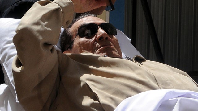 Ousted Egyptian President Hosni Mubarak gestures as he is wheeled out of a courtroom following his verdict hearing in Cairo June 2, 2012. 