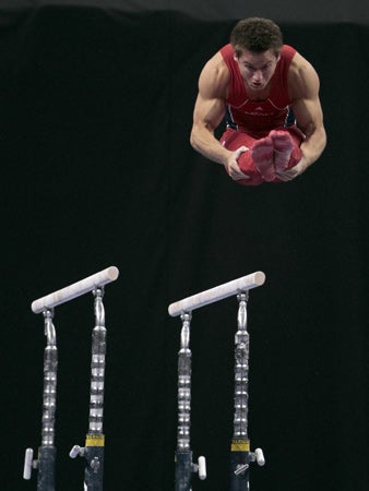 Sam Mikulak dismounts the parallel bars  