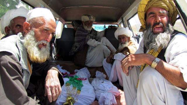 Afghan villagers sit on the back of a vehicle carrying dead bodies of children who were killed in a NATO airstrike on a home in the village of Sajawand, Afghanistan, June 6, 2012. 