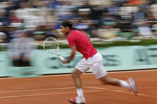 Rafael Nadal runs to the net to return against Novak Djokovic  