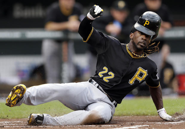 Andrew McCutchen loses his helmet as he slides into home plate 