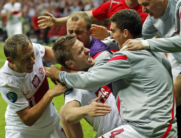 Polish players embrace Jakub Blaszczykowski, center, after he scored  during the Euro 2012 soccer  