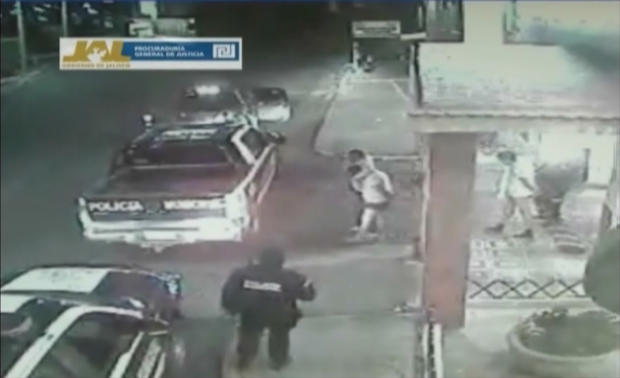 In this frame grab taken from video filmed by a surveillance camera on Jan 20, 2012, shows three men walk away from a hotel in their underwear with their hands tied behind their backs and some blindfolded, as they are led by men dressed in police uniforms toward police vehicles in Lagos de Moreno, Mexico. 