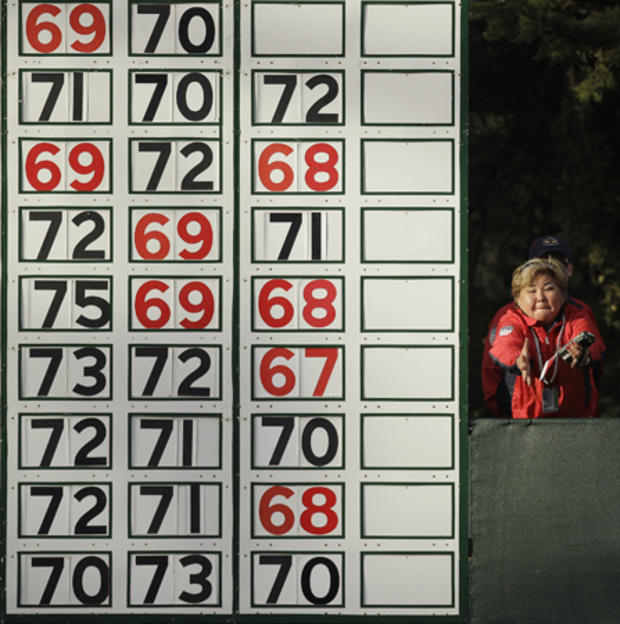 A scorekeeper catches a number that fell off the scoreboard 