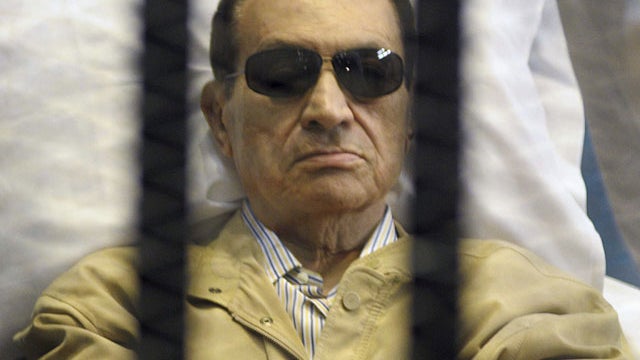 In this Saturday, June 2, 2012 file photo, Egypt's ex-President Hosni Mubarak lays on a gurney inside a barred cage in the police academy courthouse in Cairo, Egypt.  