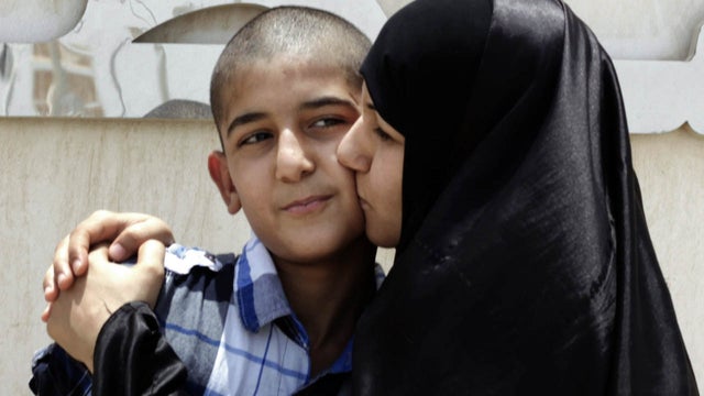 Khadija Habib, right, kisses her son, Ali Hasan, who was released from a police station, in Nabih Saleh, an island just south of the capital of Manama, Bahrain, Monday, June 11, 2012.  