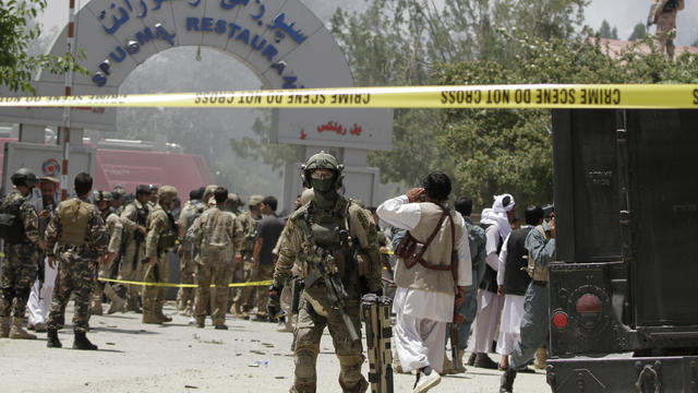 A soldier from NATO-led forces, center, is seen outside the Spozhmai hotel on Lake Qargha  