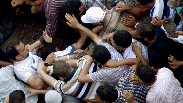 Supporters of Muslim Brotherhood presidential candidate Mohamed Morsi scramble to beat-up who they claim is a thug as they gathered in Cairo's Tahrir Square on June 22, 2012 to denounce a power grab by the ruling military. 