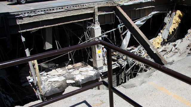 A man leans on a column next to the collapsed roof of the Algo Centre Mall in Elliot Lake, Ontario, June 23, 2012. 