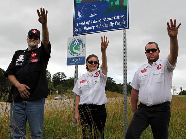 Knighthawk (from left), April Hanson and her husband Harley Hanson, members of the International Keystone Knights Realm of Georgia, perform a traditional Klan salute along the portion of highway they want to adopt . 