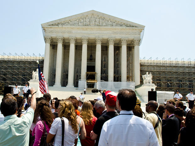WASHINGTON, DC - JUNE 28: Protestors stand outside the U.S. Supreme Court on June 28, 2012 in Washington, DC. The Court found the Affordable Healthcare Act to be constitutional and did not strike down any part of it. 