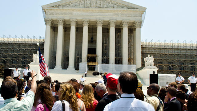 WASHINGTON, DC - JUNE 28: Protestors stand outside the U.S. Supreme Court on June 28, 2012 in Washington, DC. The Court found the Affordable Healthcare Act to be constitutional and did not strike down any part of it. 